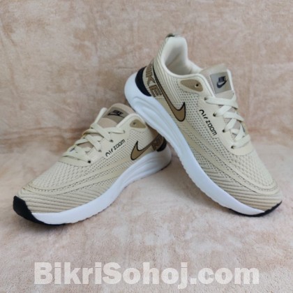 Nike Air Zoom running shoes in a light beige/tan colorway wi